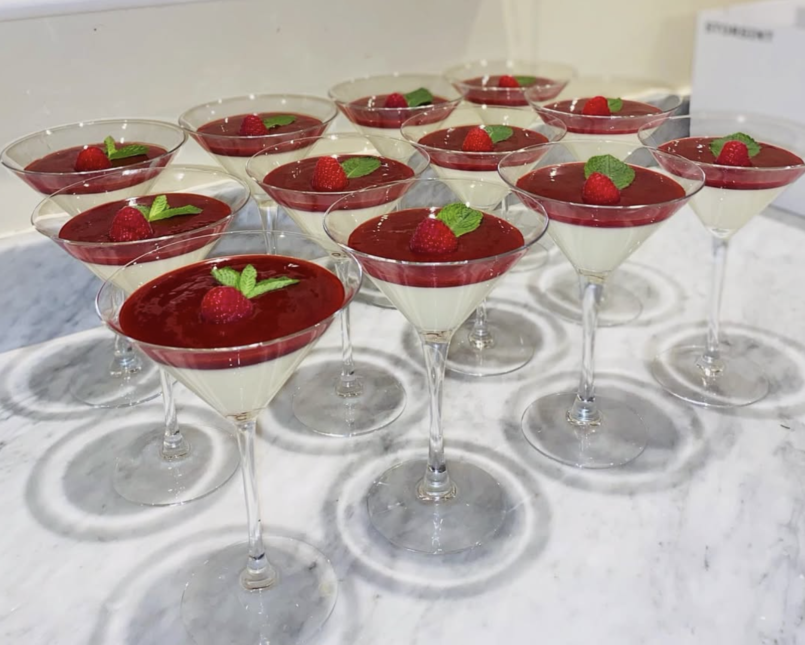 Vanilla panna cotta with raspberry coulis in martini glasses